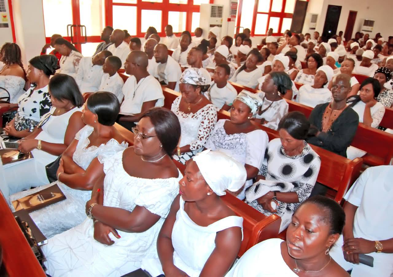 Mourners holding the official memorial service booklet, featuring the patriarch’s life story, tribute compilation, and order of service hymns.