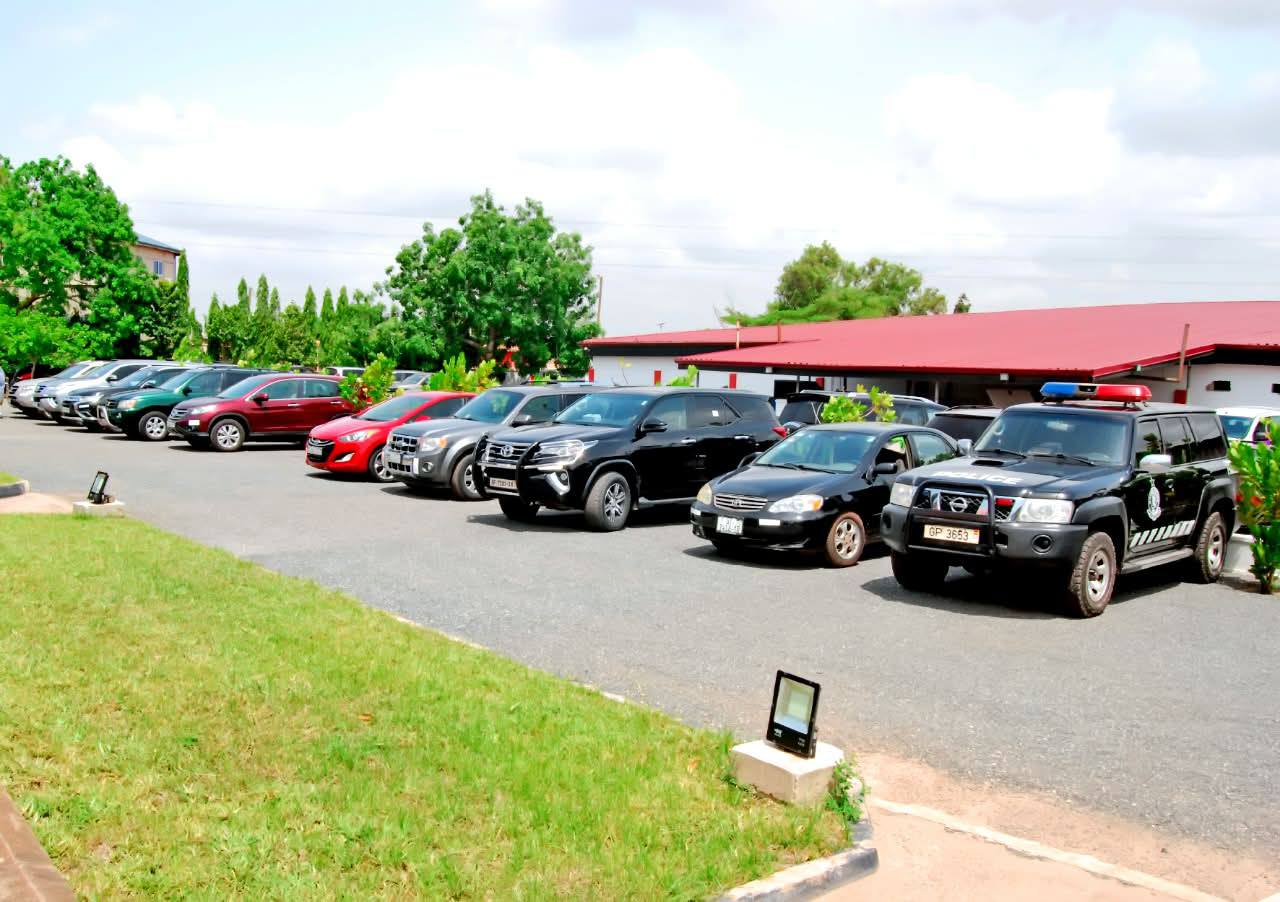 Vehicle cortege parking and security protocol escort stationed on the funeral home driveway before the committal journey.
